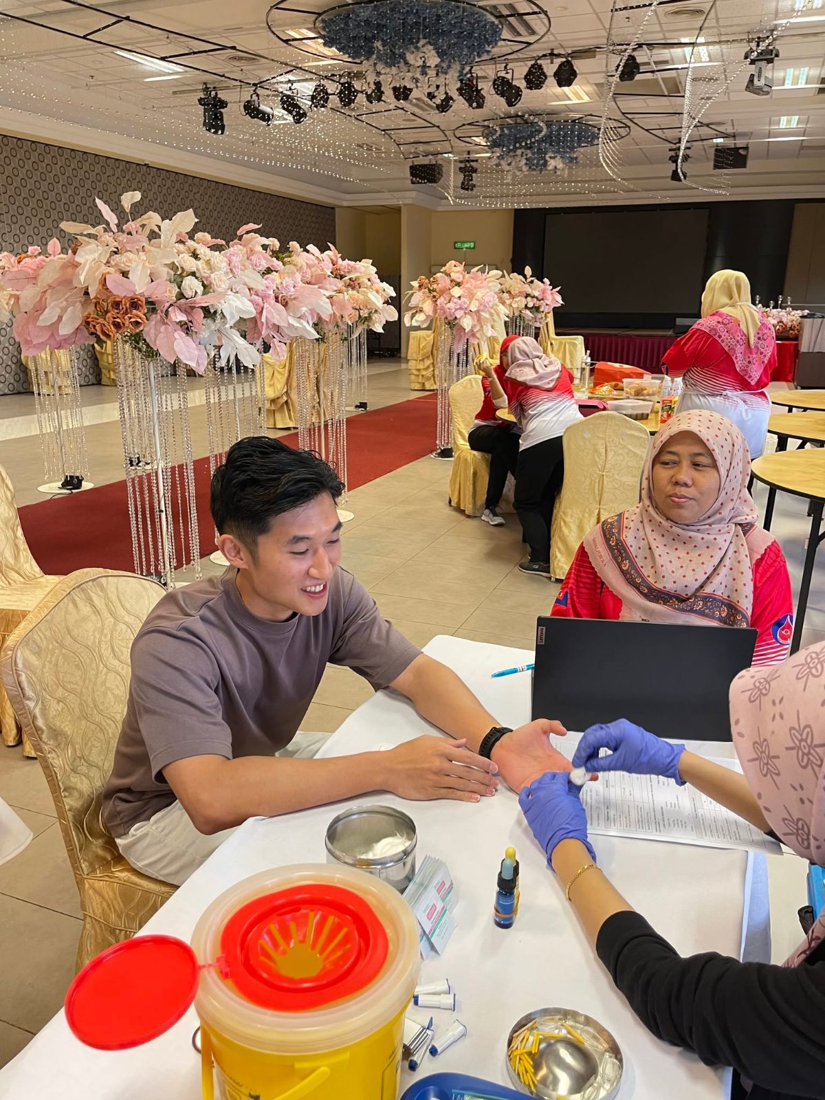 Employee donating blood with a nurse at the 2024 Blood Donation Drive