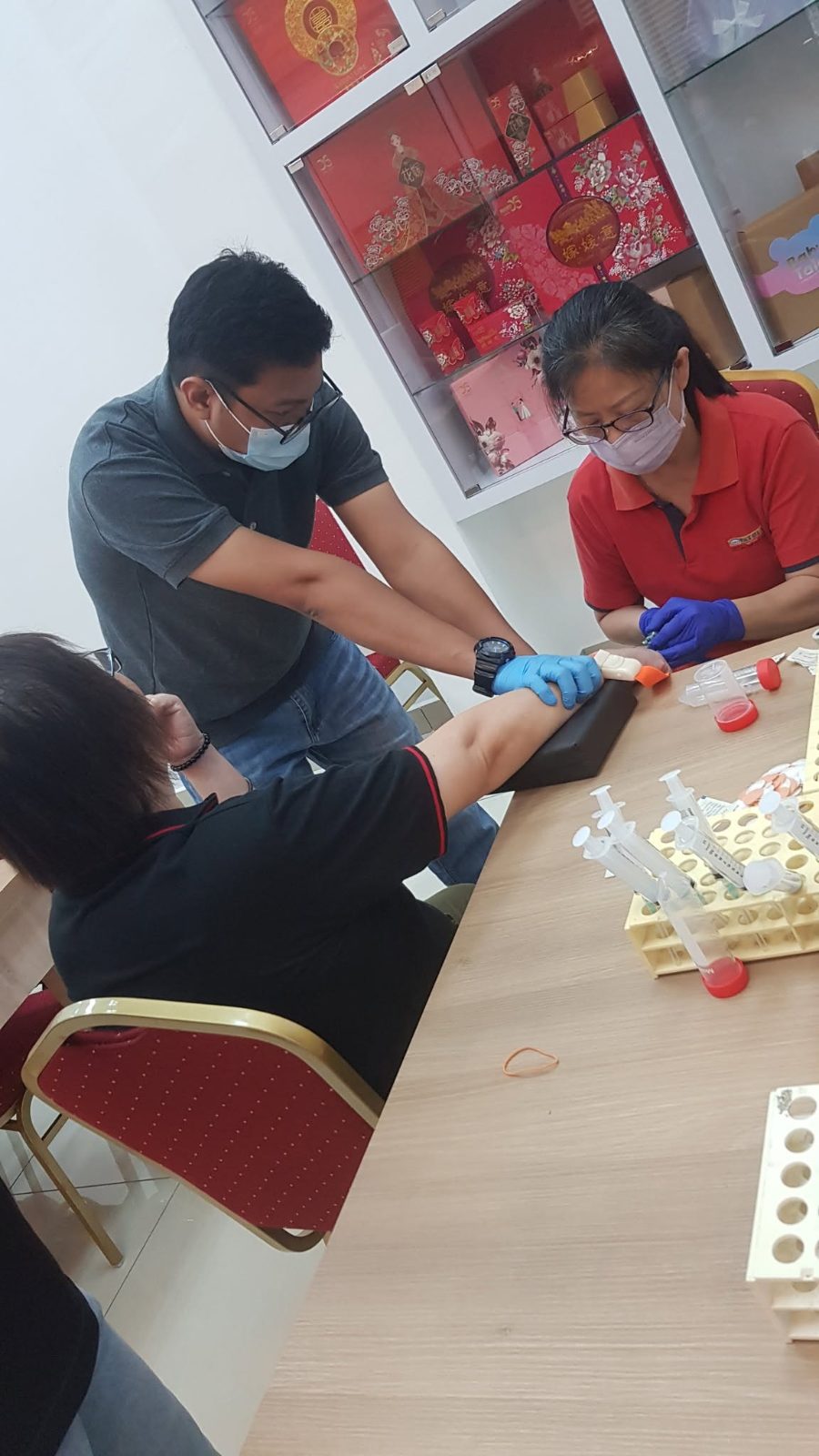 Pathlab team member taking a health screening sample from a Yummies Food employee